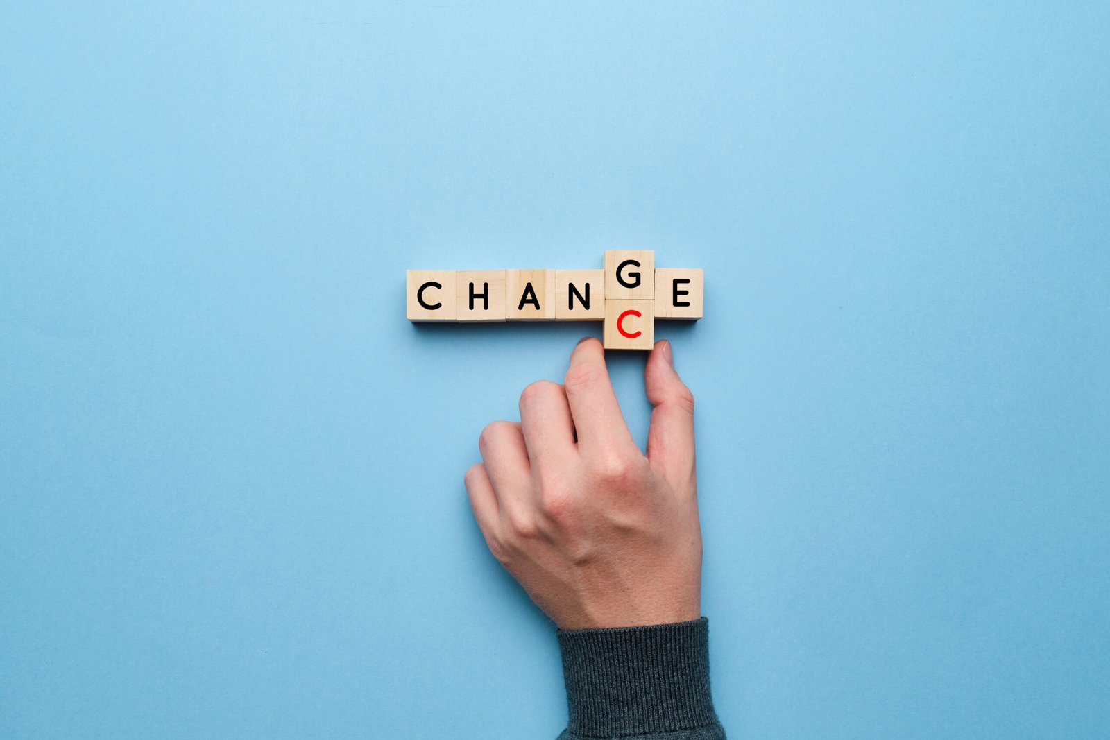 The concept of change and chance. Hand picks up letters on a yellow background